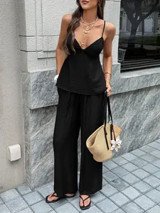Full body view of a sexy black V-neck camisole and wide-leg pants vacation two-piece set
