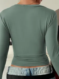 Detail of sage green slim fit long sleeve top back view showing soft fabric texture.