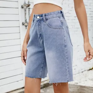 Close-up view of light wash high-waisted denim shorts with frayed raw hem details