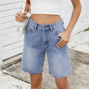 Close-up of light blue washed straight denim shorts with a fashionable frayed hemline design.