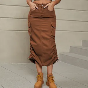 Détail d'une jupe longue cargo en denim marron avec ourlet à cordon et poches latérales