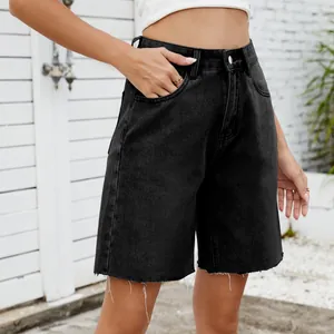 Close-up view of women's black washed denim shorts featuring raw hem and a straight fit