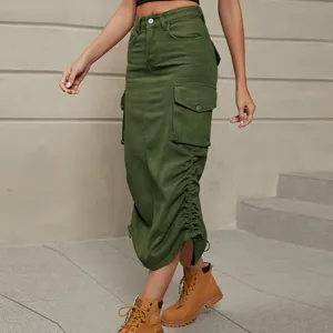 Détail d'une jupe midi cargo en jean vert olive avec poches latérales et ourlet froncé.