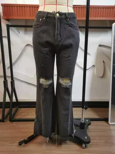 Dark grey denim micro-flare jeans featuring knee rips and raw hems on a mannequin