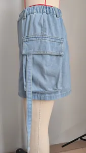 Close-up view of the side cargo pocket and decorative ribbon detail on a denim skirt
