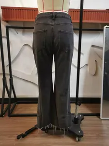 Detailed rear view of dark grey flared denim jeans with a raw hem and back pockets