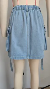 Detail view of a light blue denim cargo mini skirt featuring elastic waist and ribbons