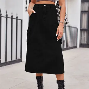 Close-up of black denim cargo midi skirt with side pockets in urban street setting