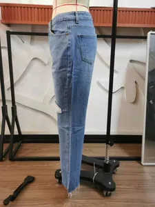 Detailed side view of light blue distressed micro-flare denim jeans on a mannequin