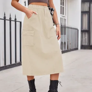 Detailed street style view of beige washed cargo denim midi skirt featuring large side flap pocket