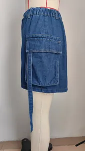 Close-up detail of a denim cargo skirt featuring a side pocket and long strap accent