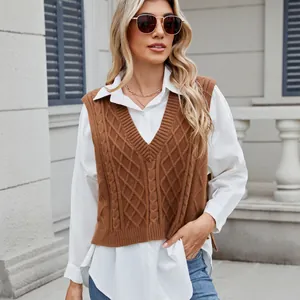 Detailed shot of a brown V-neck cable knit sweater vest layered over a white shirt.