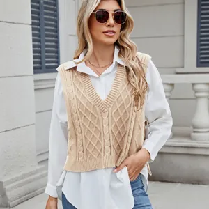Detailed view of a stylish beige V-neck cable-knit vest layered over a white shirt