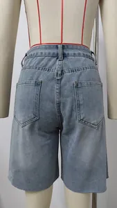 Close-up back view of light blue high-waist denim shorts with trendy frayed raw hemline