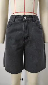 Detailed view of dark grey washed denim shorts with frayed edges and silver button.