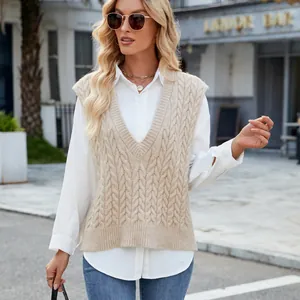 Detailed view of beige cable knit V-neck sweater vest worn over a white shirt