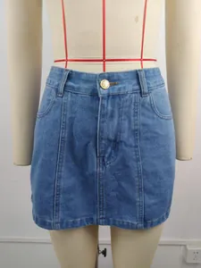 Vue détaillée de la mini-jupe en jean délavé avec bouton doré et coutures verticales.