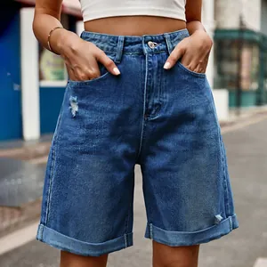 Détail de short en jean bleu à taille haute avec déchirures et ourlet revers élégant