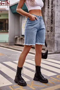 Dettaglio dei bermuda in denim a taglio vivo da donna in blu chiaro
