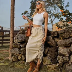 Outdoor view of a beige drawstring cargo maxi skirt styled with a white tank top