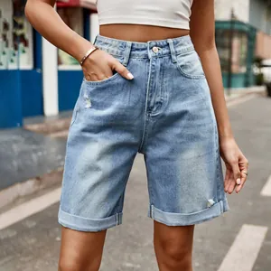 Détails d'un short en jean bleu clair à taille haute avec déchirures et revers.