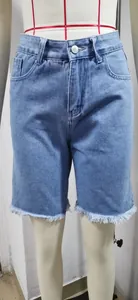 Vista dettagliata degli shorts in denim a vita alta con orlo a taglio vivo sfilacciato