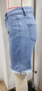 Vista laterale di pantaloncini di jeans blu a vita alta con bordo a frange alla moda
