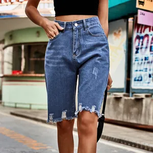 Close-up detail of high-waisted distressed denim shorts with frayed hems for women