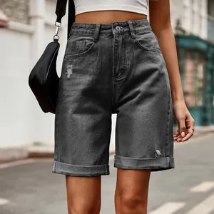 Gros plan d'un short en jean gris à taille haute avec détails déchirés et revers.