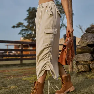 Side detail of a khaki cargo midi skirt with a functional pocket and drawstring hem.