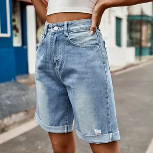 Détail montrant les ourlets déchirés et la texture du short bermuda en jean femme
