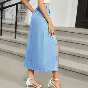 Light blue denim midi skirt detail featuring decorative side buttons and a stylish slit