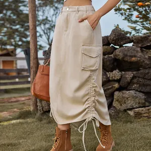 Detail view of beige cargo denim skirt with side drawstring and utility pocket