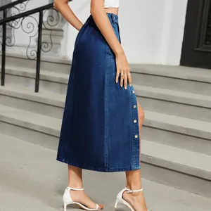 Detailed side view of a dark blue denim midi skirt with metal buttons on outdoor steps