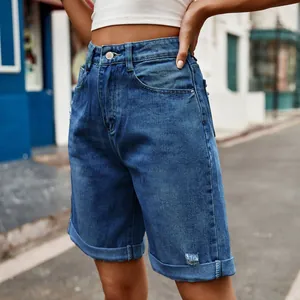 Détail de short en jean bleu délavé à taille haute avec ourlets roulés élégants