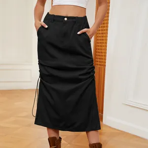 Dettaglio di gonna midi in denim nero lavato con coulisse laterali funzionali e tasche