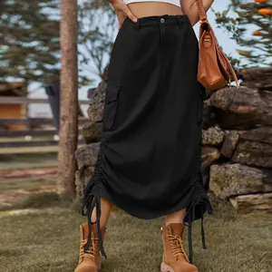 Side detail of a black denim cargo midi skirt featuring drawstring hem and large utility pockets