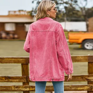 Achteraanzicht van een retro oversized roze spijkerjasje voor dames in een ranchomgeving