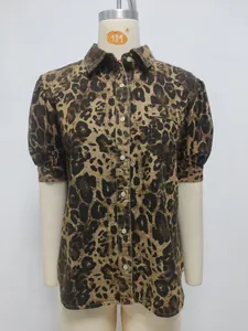 Detalle de una camisa vaquera con estampado de leopardo, mangas abullonadas y cuello solapa