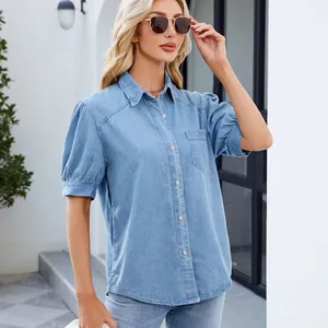 Detalle de camisa vaquera azul claro con mangas abullonadas y cuello de solapa