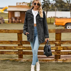Model draagt een vintage grijze denim jas in een rustieke ranchomgeving met een houten hek.