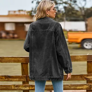 Achteraanzicht van een oversized retro zwart spijkerjack voor dames in de zon