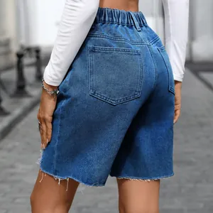 Close-up of vintage blue denim shorts featuring frayed hem and elastic waistband detail