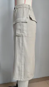 Side view of khaki cargo denim maxi skirt with large flap pockets and split hem