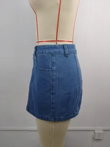 Vue latérale détaillée d'une mini-jupe en jean bleu délavé exposée sur un mannequin de couture.
