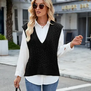 Close-up of women's black cable knit V-neck sleeveless sweater vest in urban setting