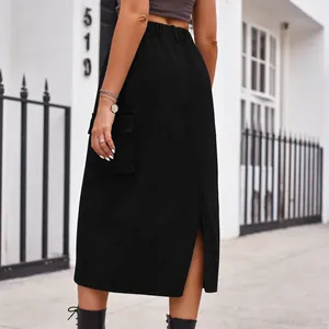 Back view detail of a black washed denim cargo midi skirt with functional pocket and slit
