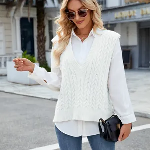Elegant white V-neck cable knit sweater vest layered over a shirt in a street style view
