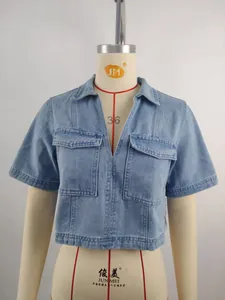 Close-up detail of a washed blue denim V-neck cropped top with front flap pockets
