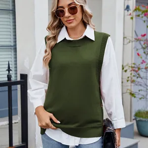 Close-up of dark green knitted vest with side button details and a split hem design
